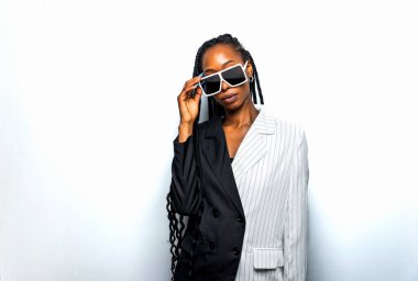 Güzel afro-amerikan kadın saçını örüyor ve şık kıyafetler giyiyor - Stüdyoda genç siyah bir kızın portresi