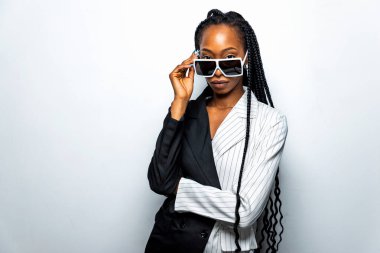 Güzel afro-amerikan kadın saçını örüyor ve şık kıyafetler giyiyor - Stüdyoda genç siyah bir kızın portresi