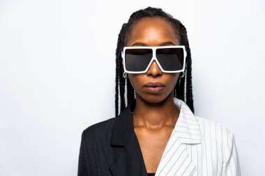 Güzel afro-amerikan kadın saçını örüyor ve şık kıyafetler giyiyor - Stüdyoda genç siyah bir kızın portresi