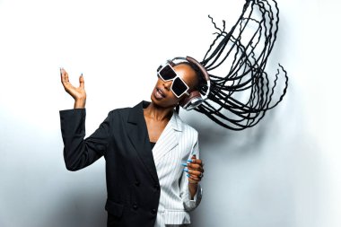 Güzel afro-amerikan kadın saçını örüyor ve şık kıyafetler giyiyor - Stüdyoda genç siyah bir kızın portresi