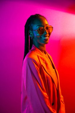 Güzel afro-amerikan kadın saçını örüyor ve şık kıyafetler giyiyor - Stüdyoda genç siyah bir kızın portresi