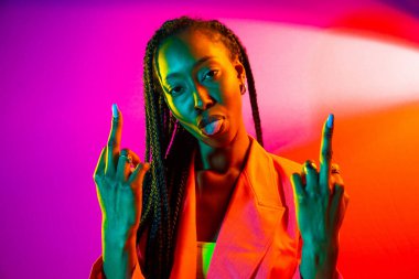 Güzel afro-amerikan kadın saçını örüyor ve şık kıyafetler giyiyor - Stüdyoda genç siyah bir kızın portresi