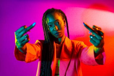 Güzel afro-amerikan kadın saçını örüyor ve şık kıyafetler giyiyor - Stüdyoda genç siyah bir kızın portresi