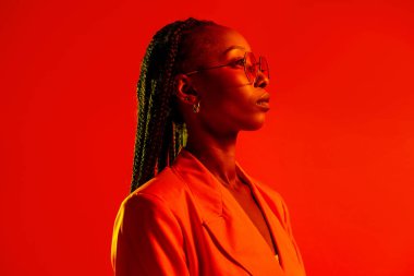 Güzel afro-amerikan kadın saçını örüyor ve şık kıyafetler giyiyor - Stüdyoda genç siyah bir kızın portresi