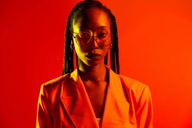 Güzel afro-amerikan kadın saçını örüyor ve şık kıyafetler giyiyor - Stüdyoda genç siyah bir kızın portresi