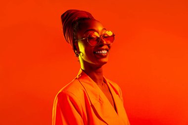 Güzel afro-amerikan kadın saçını örüyor ve şık kıyafetler giyiyor - Stüdyoda genç siyah bir kızın portresi