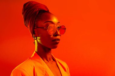 Güzel afro-amerikan kadın saçını örüyor ve şık kıyafetler giyiyor - Stüdyoda genç siyah bir kızın portresi