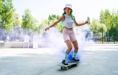 Renkli sis bombalı patenciler. Profesyonel kaykaycılar kaykay parkında eğleniyor.