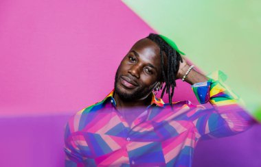 Jel lambalı sanatsal portre. Renkli arka planlarda poz veren yakışıklı bir adam.