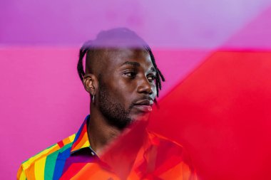 Jel lambalı sanatsal portre. Renkli arka planlarda poz veren yakışıklı bir adam.