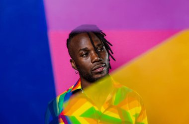 Jel lambalı sanatsal portre. Renkli arka planlarda poz veren yakışıklı bir adam.