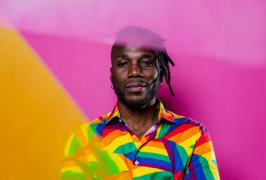 Jel lambalı sanatsal portre. Renkli arka planlarda poz veren yakışıklı bir adam.