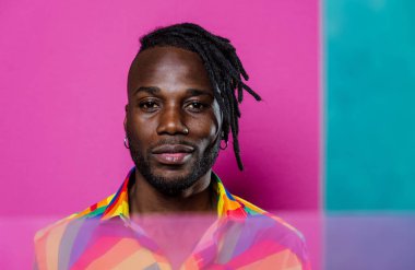 Jel lambalı sanatsal portre. Renkli arka planlarda poz veren yakışıklı bir adam.