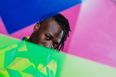 Jel lambalı sanatsal portre. Renkli arka planlarda poz veren yakışıklı bir adam.