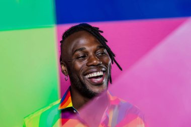 Jel lambalı sanatsal portre. Renkli arka planlarda poz veren yakışıklı bir adam.