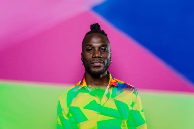 Jel lambalı sanatsal portre. Renkli arka planlarda poz veren yakışıklı bir adam.