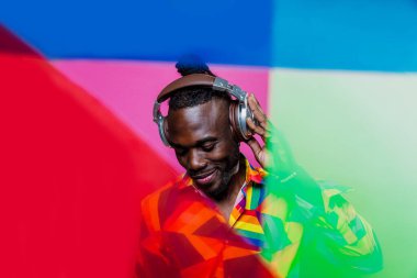 Jel lambalı sanatsal portre. Renkli arka planlarda poz veren yakışıklı bir adam.