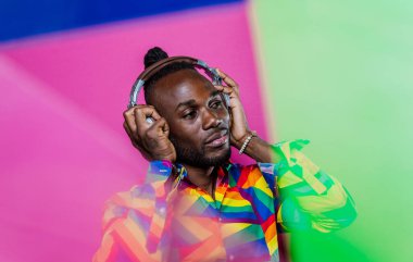 Jel lambalı sanatsal portre. Renkli arka planlarda poz veren yakışıklı bir adam.