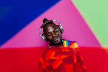 Jel lambalı sanatsal portre. Renkli arka planlarda poz veren yakışıklı bir adam.