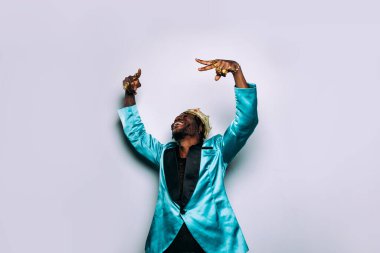 Bir hip hop müzisyeninin portresi. Parti kıyafetleri ve mücevherler giyen bir adamın sinematik görüntüsü.