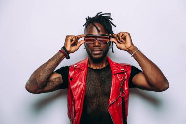 Kırmızı deri ceket giyen yakışıklı bir adam. Gelecekçi siber punk tarzı. Beyaz arkaplanda stüdyo ışığı görüntüsü