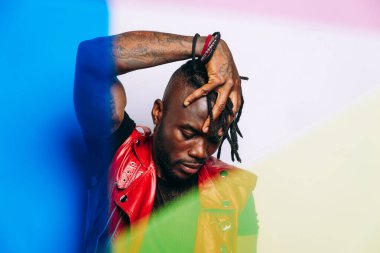 Kırmızı deri ceket giyen yakışıklı bir adam. Gelecekçi siber punk tarzı. Beyaz arkaplanda stüdyo ışığı görüntüsü