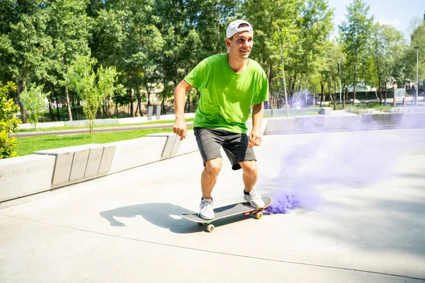 色の煙爆弾を持つスケーター スケートパークで楽しんでいるプロのスケートボーダー — ストック写真