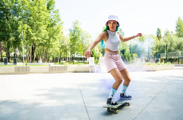 skaters with colored smoke bombs. Professional skateboarders having fun at the skate park