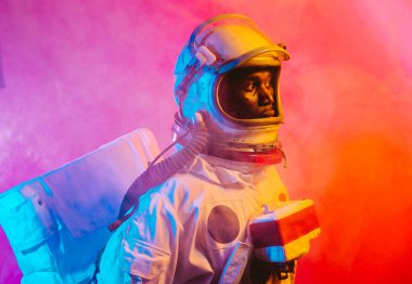 Bir astronotun sinematik görüntüsü. Uzay elbisesi olan bir adamın renkli portresi.