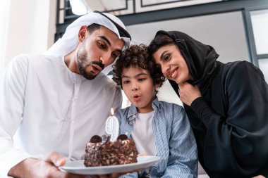 Mutlu aile birlikte vakit geçiriyor. Arap ailesi ve çocuk birlikte doğum gününü kutluyorlar.