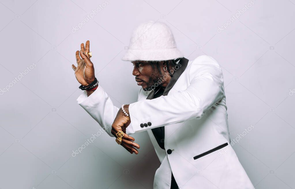 Portrait of an hip hop music musician. Cinematic image of a man wearing white clothes and jewels