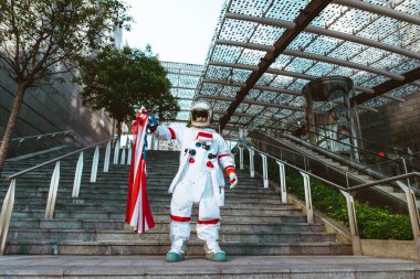 Fütürist bir istasyonda uzay adamı. Uzay giysili bir adam şehir bölgesinde yürüyor.