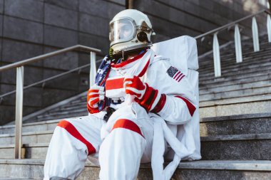 Fütürist bir istasyonda uzay adamı. Uzay giysili bir adam şehir bölgesinde yürüyor.