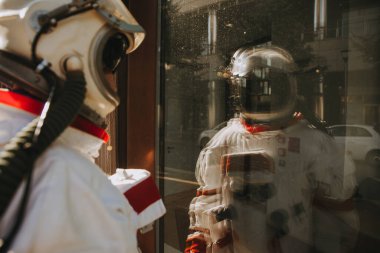 Fütürist bir istasyonda uzay adamı. Uzay giysili bir adam şehir bölgesinde yürüyor.