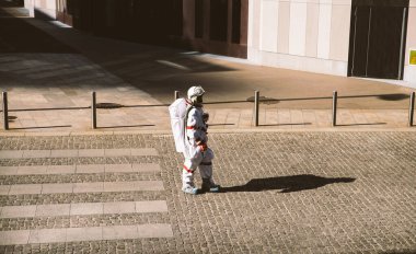 Fütürist bir istasyonda uzay adamı. Uzay giysili astronot kentsel alanda yürüyor.