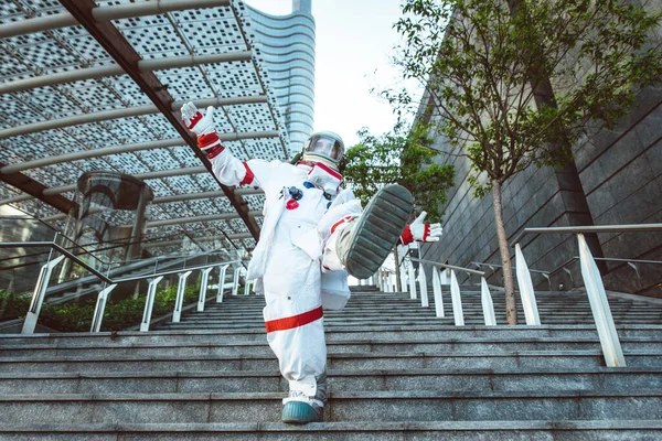 未来の駅の宇宙飛行士 宇宙服を着た男が都市部を歩く — ストック写真