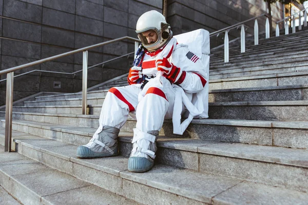 未来の駅の宇宙飛行士 宇宙服を着た男が都市部を歩く — ストック写真