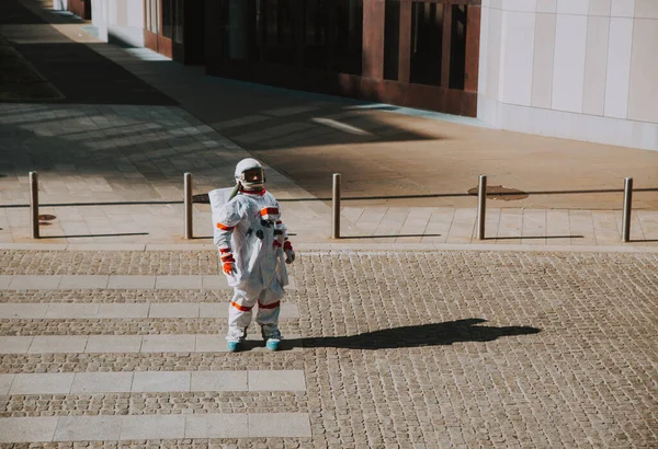 宇宙飛行士は未来の駅で 宇宙服を着た宇宙飛行士が都市部を歩き — ストック写真
