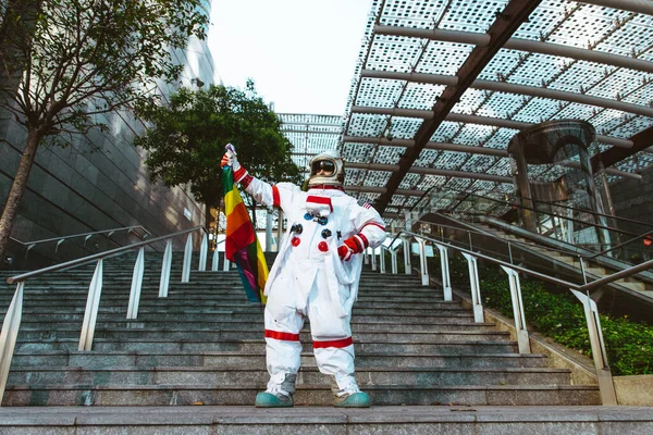 将来の駅にいるLbt宇宙飛行士 宇宙服を着た男が都市部を歩く — ストック写真