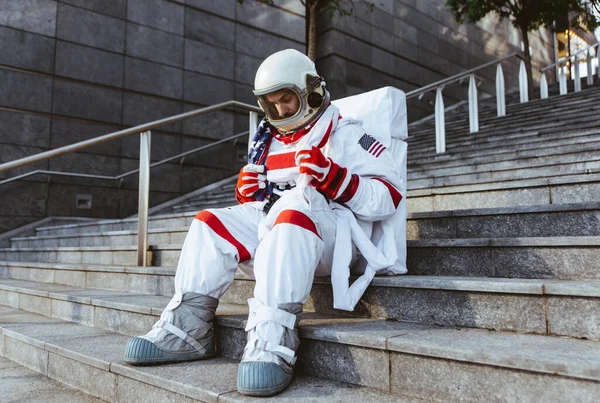 未来の駅の宇宙飛行士 宇宙服を着た男が都市部を歩く — ストック写真