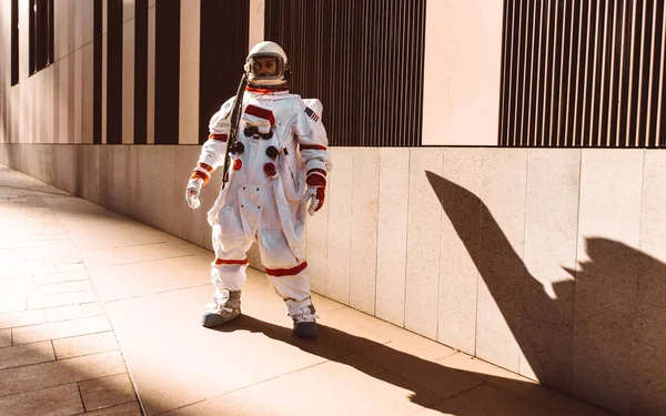 未来の駅の宇宙飛行士 宇宙服を着た男が都市部を歩く — ストック写真