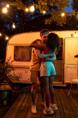 Karavanla tatile çıkan genç bir çift. Gece vakti açık havada dans etmek. Seyahat tutkusu seyahatleri ve tatildeki yaşam tarzını düşün.