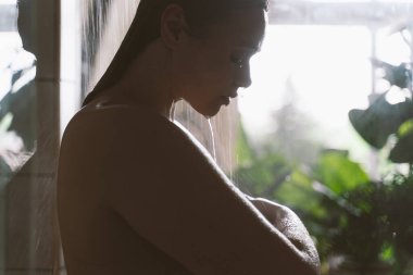 Evdeki genç bir kadının yaşam tarzı. Sabah duş alan bir kadın.