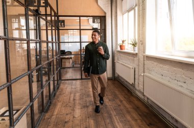 Ofis koridorlarında yürüyen genç bir iş adamı. iş ve insanlar hakkındaki konsept