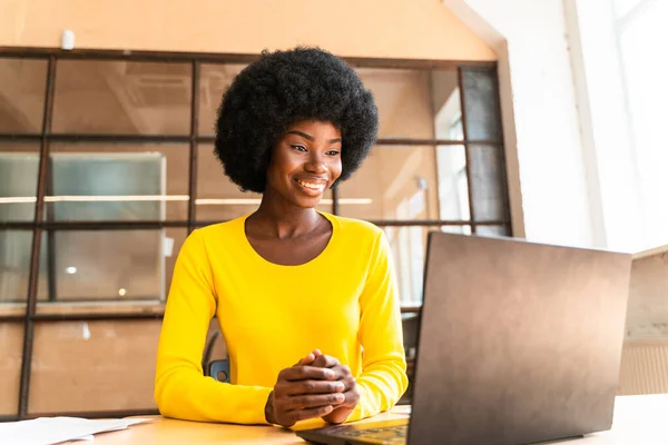 beautiful young woman with the afro haircut working in the office