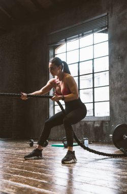 Güzel bir kadın antrenmanı ve spor salonunda egzersiz yapıyor.