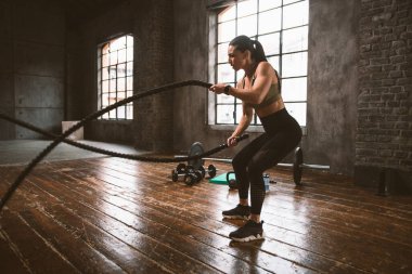 Güzel bir kadın antrenmanı ve spor salonunda egzersiz yapıyor.