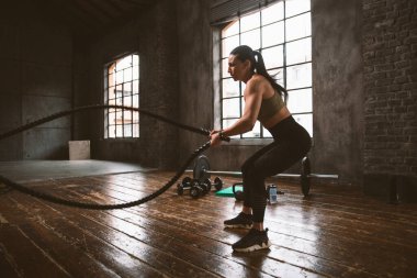 Güzel bir kadın antrenmanı ve spor salonunda egzersiz yapıyor.