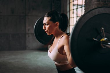 Güzel bir kadın antrenmanı ve spor salonunda egzersiz yapıyor.