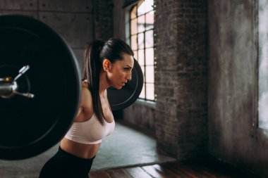 Güzel bir kadın antrenmanı ve spor salonunda egzersiz yapıyor.